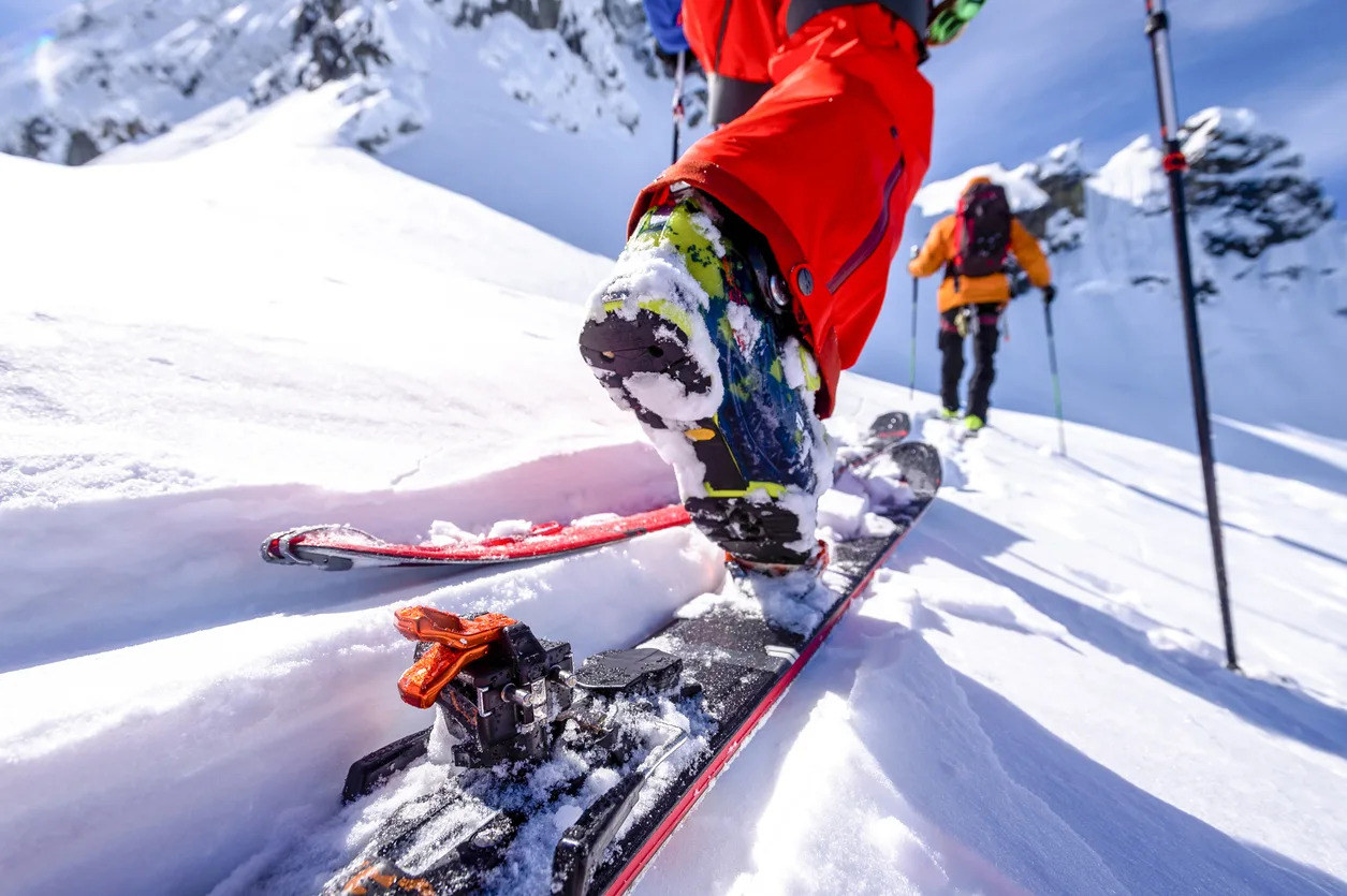 POV of backcountry skiers climbing snow slope